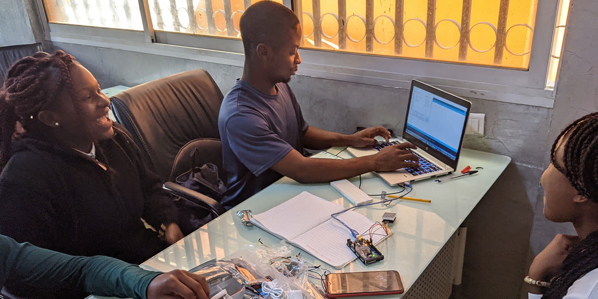Students working with a laptop and electronics around a table